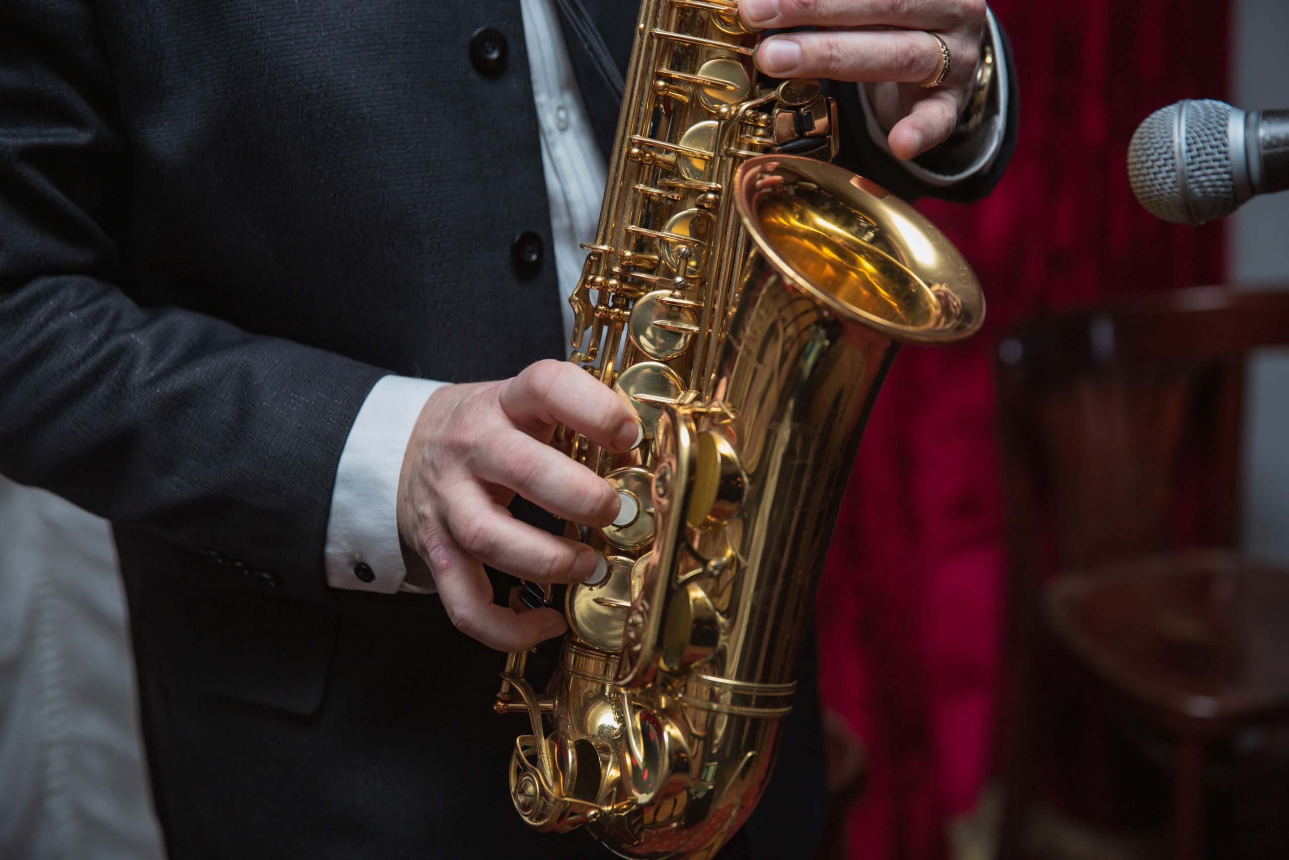 Saxophone player. Saxophonist hands playing saxophone. Alto sax player with jazz music instrument closeup
